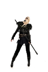 full length portrait of blonde girl wearing lack fantasy warrior outfit. standing pose wit bak to...