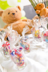 Glasses of Bagged Sweets on White Table with Teddy Bears in Background