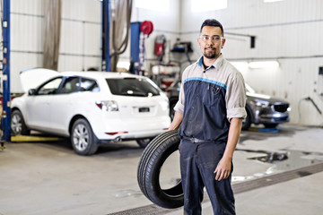Obraz na płótnie Canvas Mechanic changing car tire at work