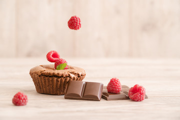 Delicious chocolate lava cake with fresh falling raspberries and mint