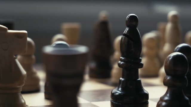 A close-up of a black bishop during a chess game.