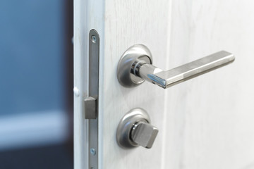 Fototapeta premium Detail of a metallic knob on white door horizontal