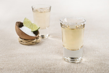 Authentic shot of Tequila Mexican traditional drink accompanied with lime and salt Tequila shot composition
