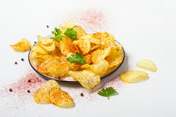 Crispy potato chips on a plate on a white background