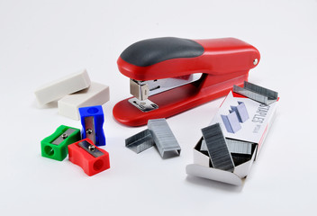 Stationery stapler, erasers, sharpeners on white background.