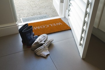 Various shoes kept on a door mat