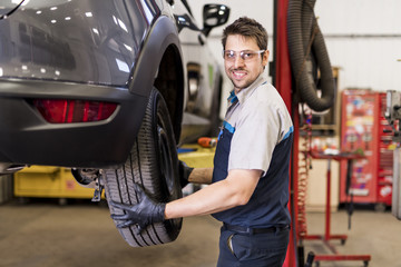 Handsome mechanic job in uniform working on car