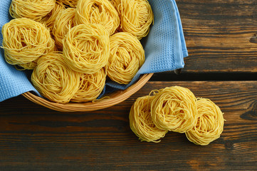 egg noodles in basket on wooden floor.