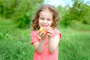 cute baby girl stretches out a red Apple.	
