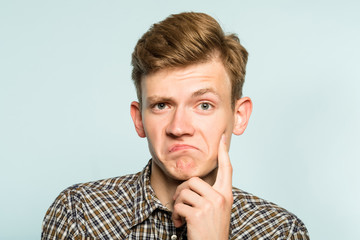 not bad. approval judgement. accepting man with raised eyebrow. portrait of a young guy on light...