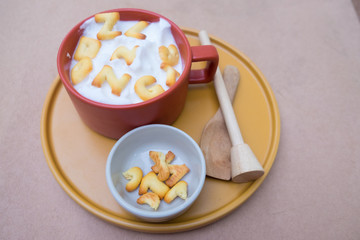 A cup of hot milk with biscuit