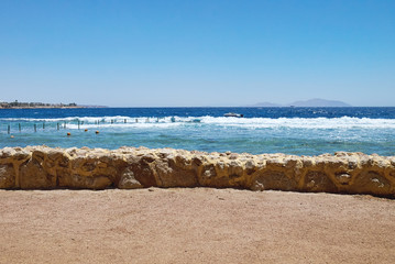 Sea beach with a boat floating on waves