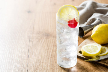 Classic Tom Collins cocktail on wooden table. Copyspace