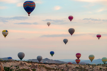 Hot air balloons at sunrise flying over Cappadocia, Goreme, Turkey.