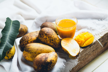 nature mango and mango juice On a wooden table and a white cloth