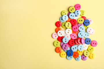 Many multicolored buttons on a yellow background.