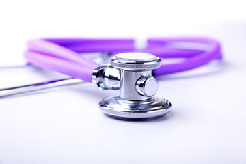 Medical stethoscope and red heart close-up on white background.