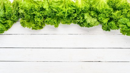 Fresh green lettuce. Fresh vegetables. On a wooden background. Top view. Copy space.