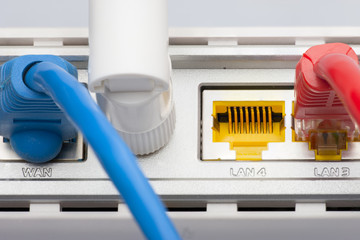 Modem router network hub with cable connecting. Bright blue and red cables and connectors.