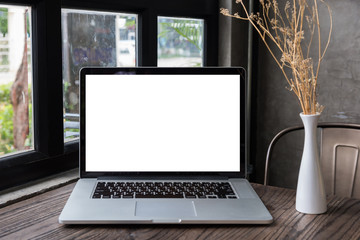 blank screen laptop computer on wooden table, dark background
