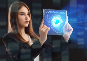 The concept of business, technology, the Internet and the network. A young entrepreneur working on a virtual screen of the future and sees the inscription: Outsourcing