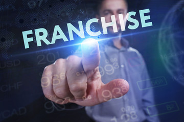 The concept of business, technology, the Internet and the network. A young entrepreneur working on a virtual screen of the future and sees the inscription: Franchise