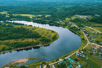 Top view of the river, green forests and the village. Karelia, Russia.