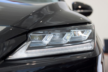 New modern vehicle with elegant head lamps. Front view.