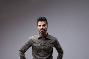 Confident young adult male with hands on hips