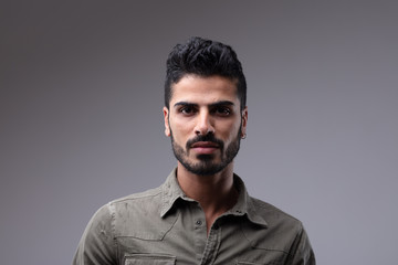 Fototapeta premium Young man with beard wearing grey button shirt