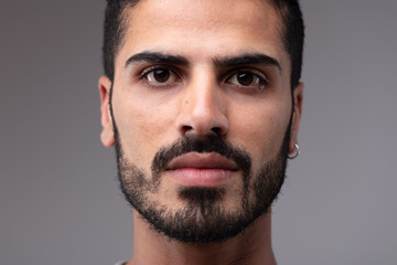 Headshot of young bearded man with earing