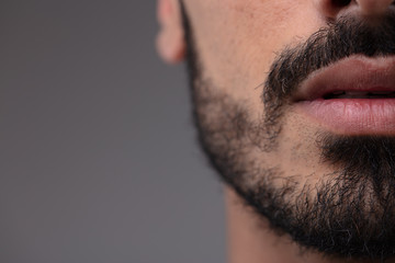 Cropped view of the mouth of a bearded man