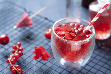 Red berries cocktail with flowers close up on the dark backdround