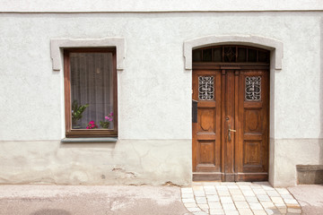 Fototapeta na wymiar Old European housing front / facade with plastered walls and antique doors.