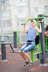 boy teenager engaged in children's exercise equipment