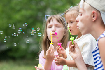 Fototapeta premium children blowing soap bubbles