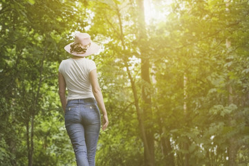 девушка в шляпе гуляет по лесу в солнечный день