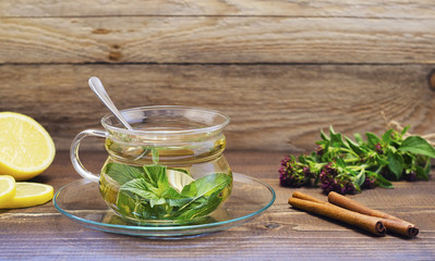 mint tea in a glass transparent cup on a saucer with lemon and cinnamon 2