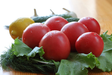 Group of red ripe tomatoes with water drops lie on a lettuce leaves