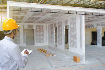 Male engineer inspection writing in factory With note on notepad or