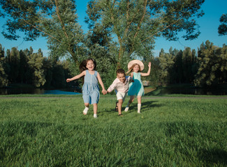 little kids playing around on the lawn. two girls and a boy