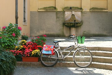 Fototapeta na wymiar Lovely decorated stairs and bicycle on a little square in Italy