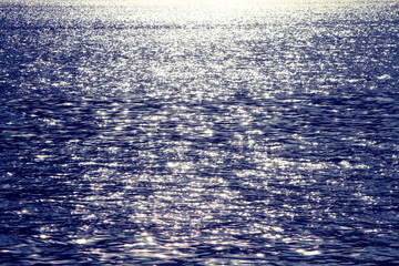 Blue water glistening in the evening sun texture background