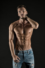 Check out my shape. Man muscular torso tense muscles veins denim pants. Macho muscular chest looks attractive black background. Athlete with muscular body on confident face proud of his shape