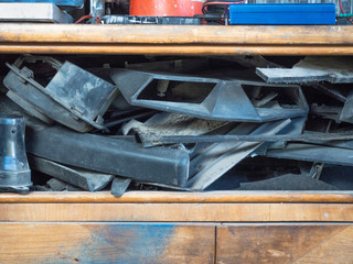 An old wooden box with different devices and motor vehicle parts piled together on its shelves....