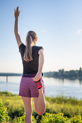 Sport and fitness. Young woman training outdoor at sunrise with urban background.