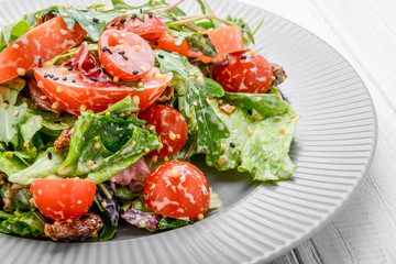 Salad with fresh vegetables with dried tomatoes, meat and mustard.