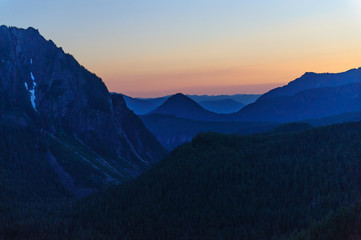 The Setting sun illuminates an orange-reddish night sky in mount Rainier National Park
