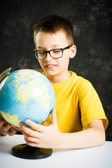 Schoolboy exploring world through a globe