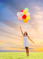 happiness, summer and people concept - smiling young woman wearing sunglasses with balloons on...